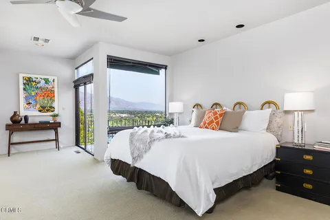 a spacious bedroom with a bed and large window