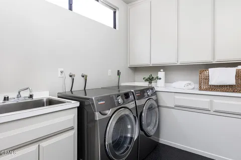 a utility room with sink dryer and washer