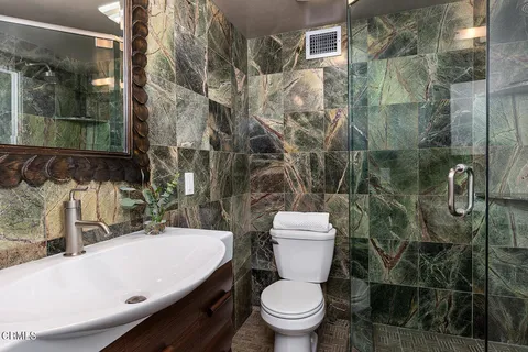 a white toilet sitting next to a bathroom sink and shower