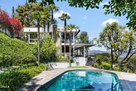 a view of a house with fountain and potted plants