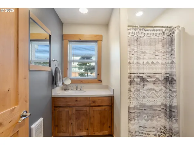 a bathroom with a granite countertop sink a mirror and a shower