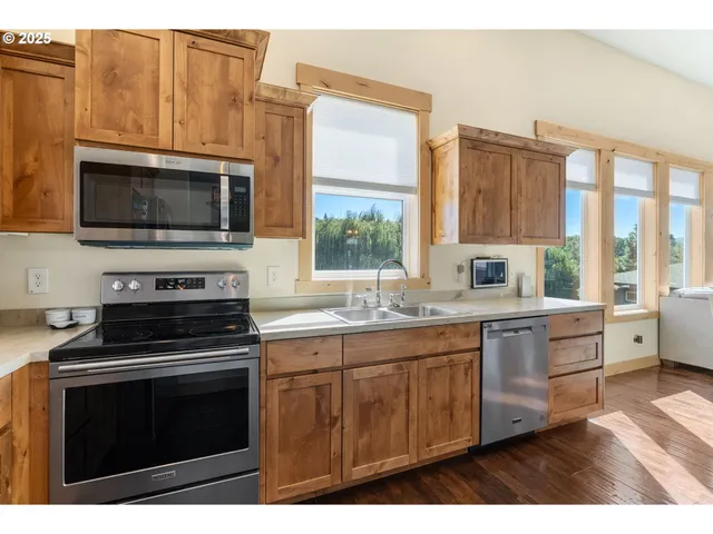 a kitchen with stainless steel appliances a stove sink and microwave