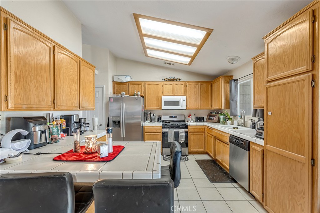 19084 Rock Springs Road Hesperia, CA 92345 - Photo 11 of 44 a kitchen with a sink stove and chairs