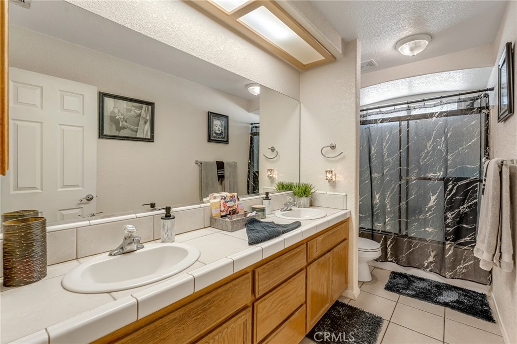 19084 Rock Springs Road Hesperia, CA 92345 - Photo 15 of 44 a bathroom with double vanity and a shower