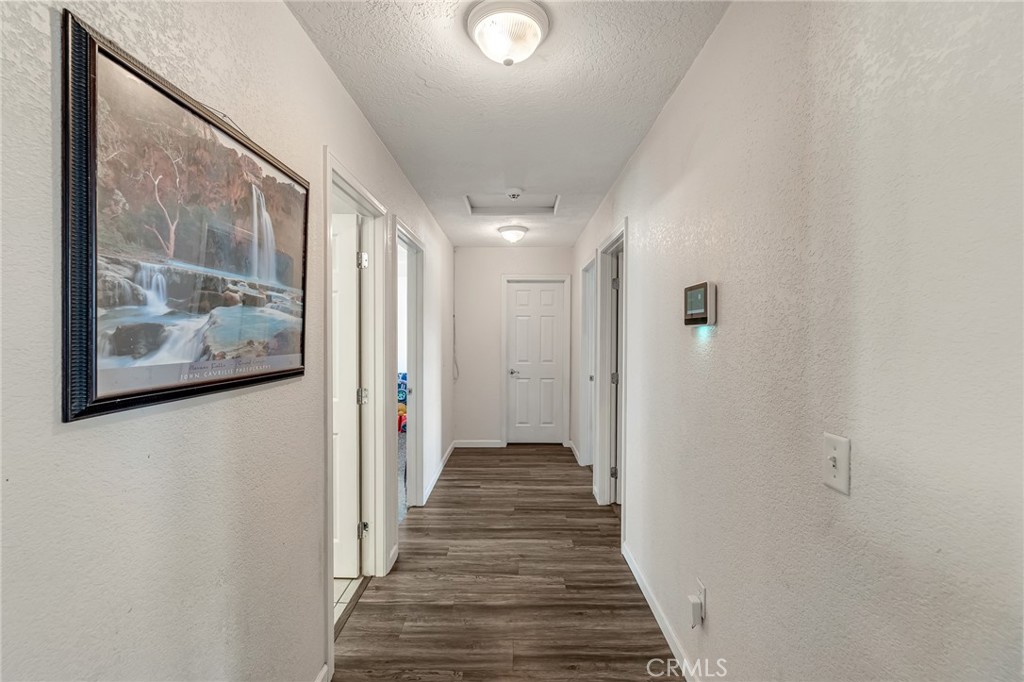 19084 Rock Springs Road Hesperia, CA 92345 - Photo 17 of 44 a view of a hallway with wooden floor and front door