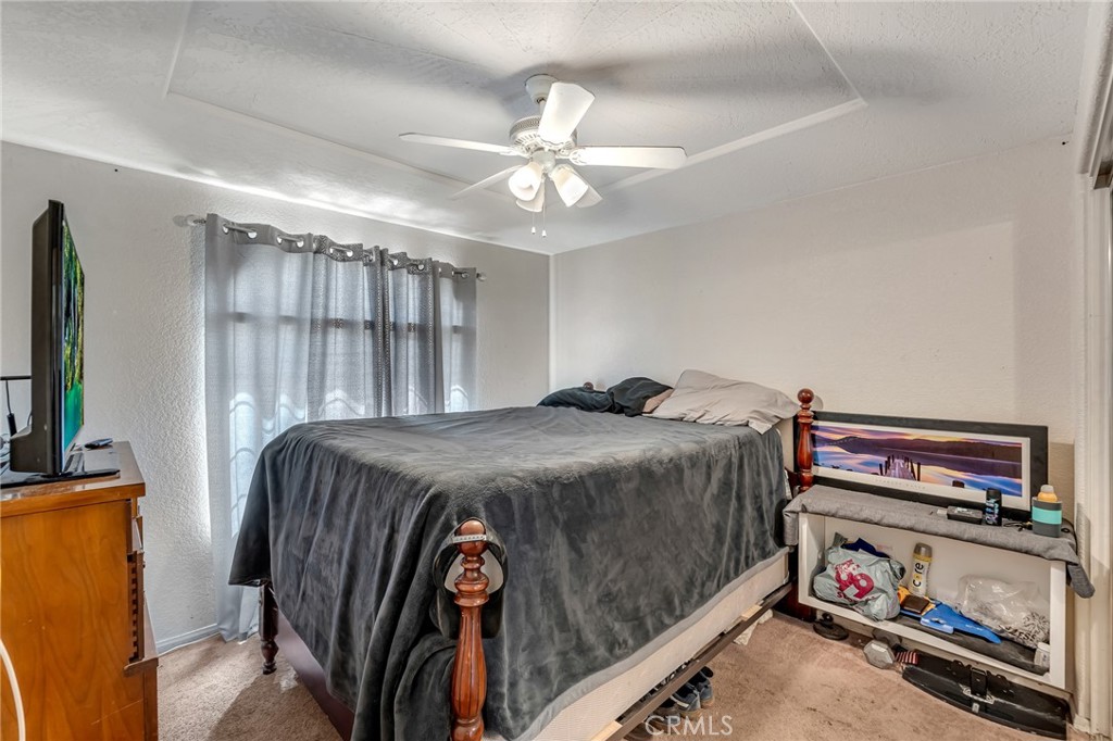 19084 Rock Springs Road Hesperia, CA 92345 - Photo 19 of 44 a bedroom with a bed and a chandelier