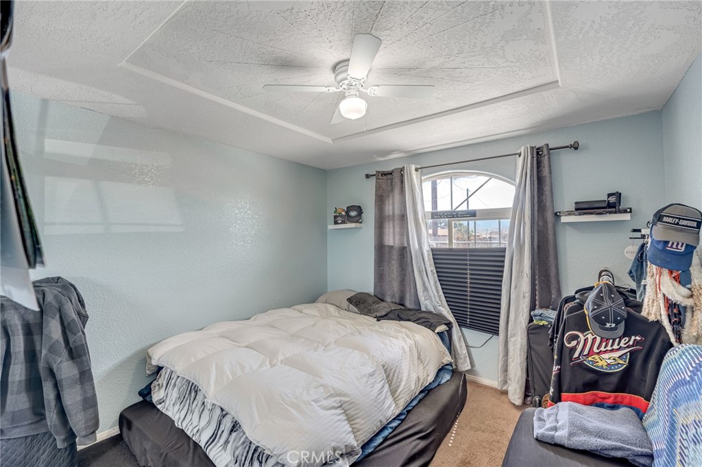 19084 Rock Springs Road Hesperia, CA 92345 - Photo 21 of 44 a bedroom with a bed and a chandelier