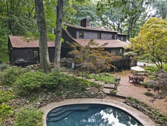 an aerial view of a house with a yard and large trees