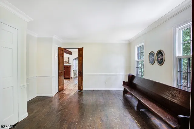 a hallway with wooden floor and a workspace