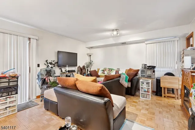 a living room with furniture a flat screen tv and a window