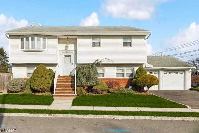 a front view of a house with garden and plants
