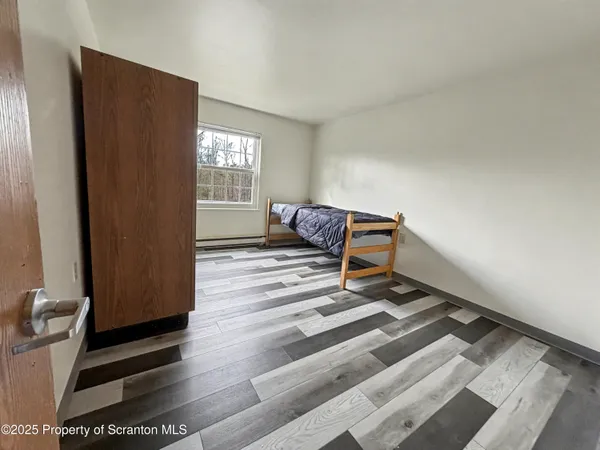 a bedroom with a bed and wooden floor