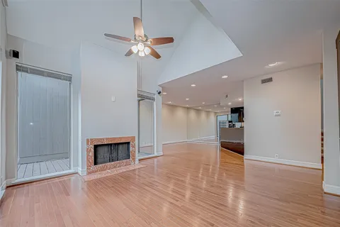 a view of empty room with wooden floor and fireplace