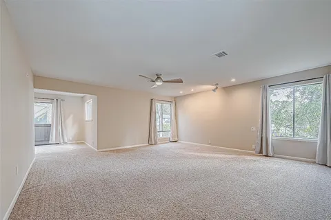 an empty room with a hallway and wooden floor