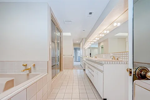 a spacious bathroom with a sink a mirror and a bathtub