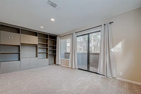 a view of an empty room with closet and racks
