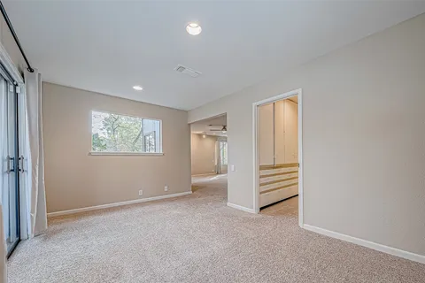 an empty room with a hallway and wooden floor