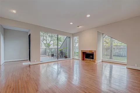 an empty room with wooden floor and a fireplace