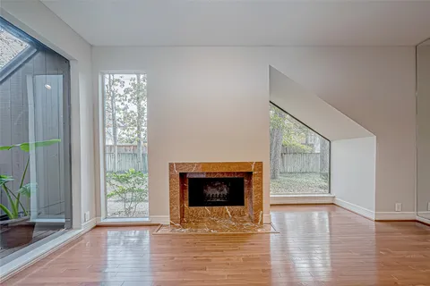 a view of an empty room with glass door and wooden floor