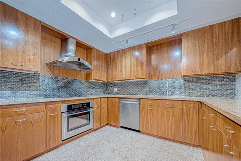 a kitchen with stainless steel appliances granite countertop a sink and cabinets with wooden floor