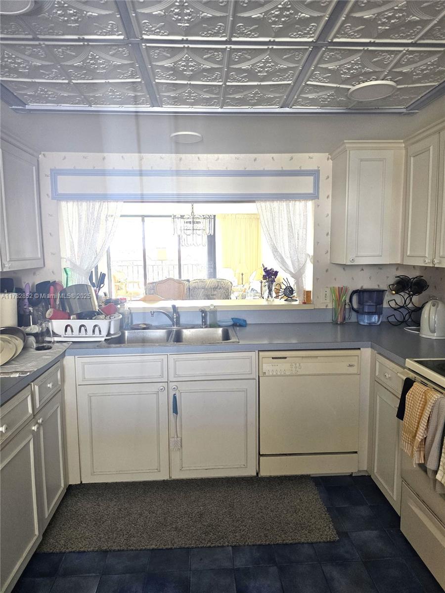 7020 Half Moon Circle, Unit 511 Hypoluxo, FL 33462 - Photo 12 of 28 a kitchen with granite countertop a sink and white cabinets
