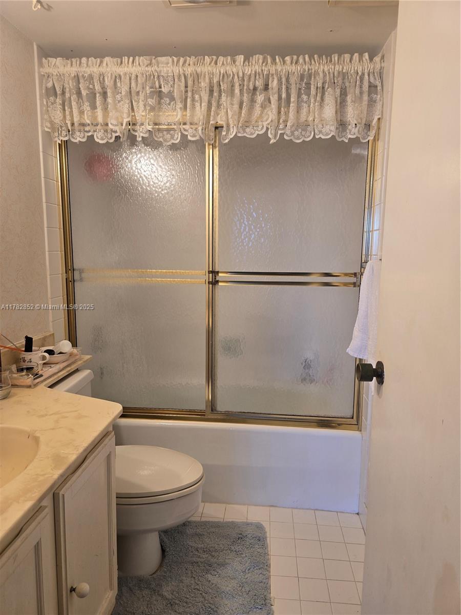 7020 Half Moon Circle, Unit 511 Hypoluxo, FL 33462 - Photo 13 of 28 a bathroom with a granite countertop shower a toilet and a sink