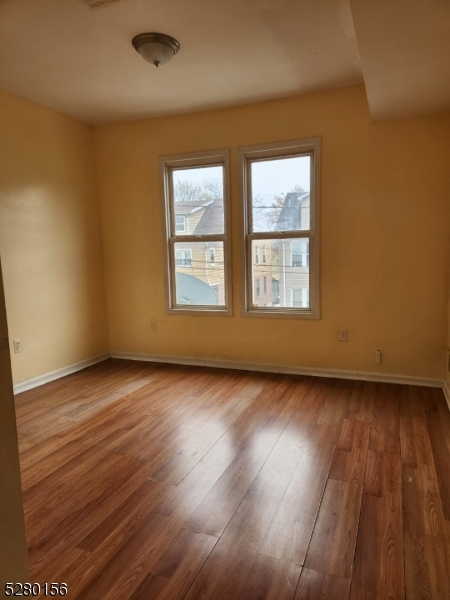 283 Lehigh Avenue Newark, NJ 07112 - Photo 2 of 9 an empty room with wooden floor and windows