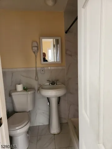 a bathroom with a sink toilet and a mirror