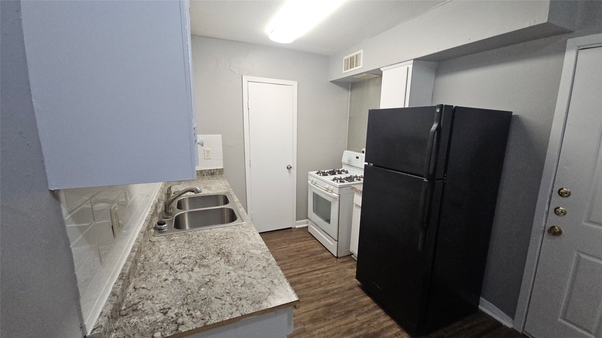 10806 Safeguard Street Houston, TX 77047 - Photo 6 of 10 a kitchen with a refrigerator and a sink