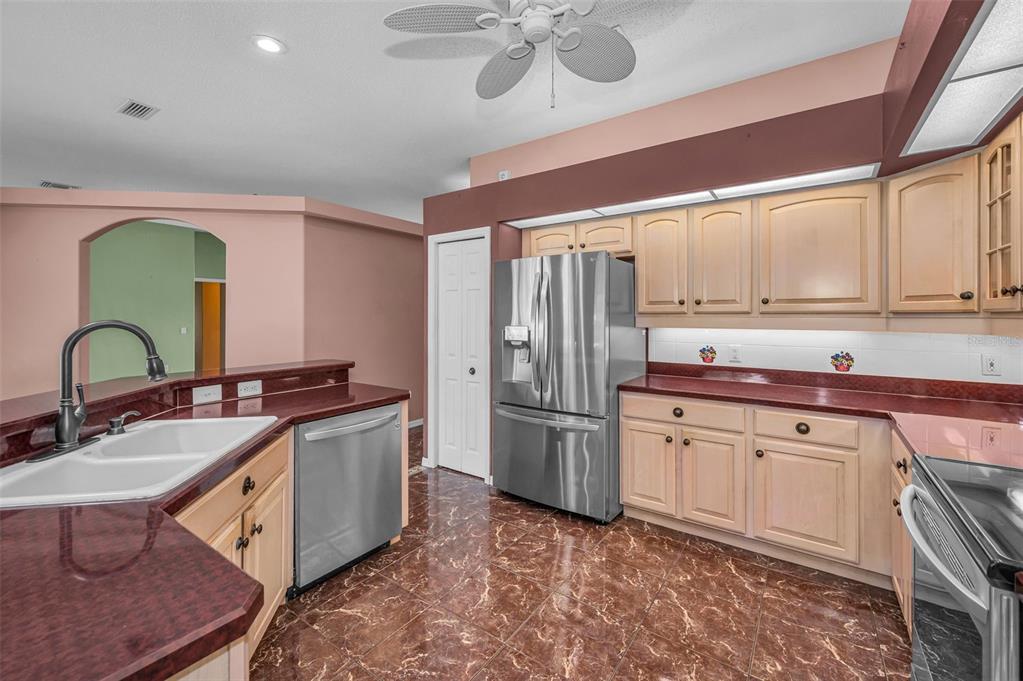 11917 Hadleigh Way Trinity, FL 34655 - Photo 15 of 84 a kitchen with stainless steel appliances granite countertop a sink stove and refrigerator