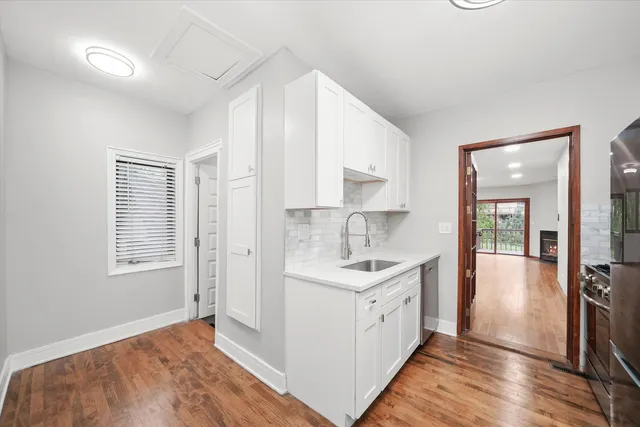 a view of a kitchen counter space with wooden floor and staircase