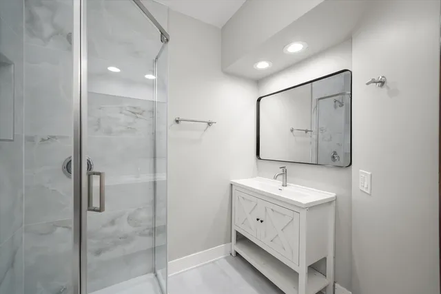 a bathroom with a double vanity sink mirror and shower