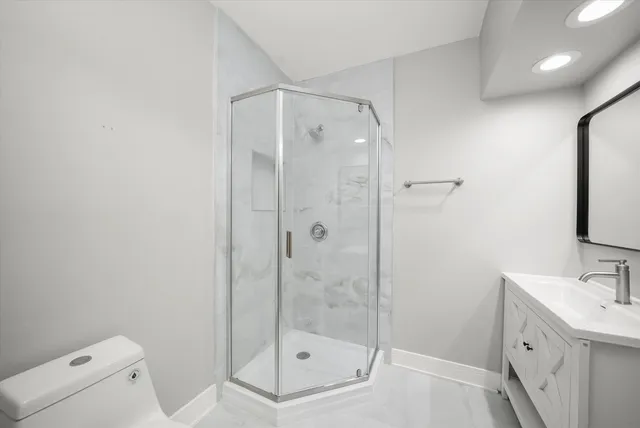 a bathroom with a shower a sink and toilet