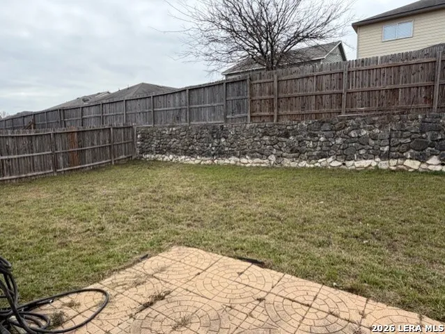 a view of a yard with wooden fence