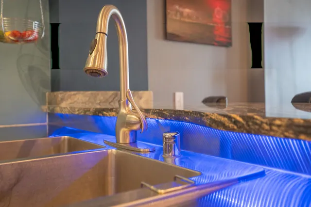 a kitchen with stainless steel appliances kitchen island granite countertop a sink a table and chairs