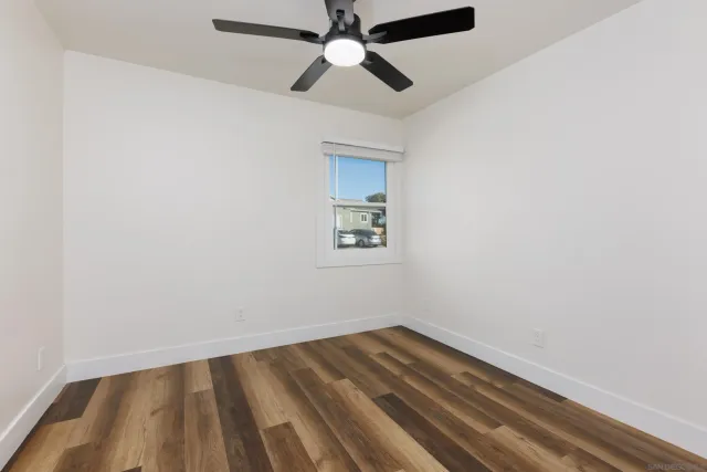 an empty room with a window and a ceiling fan