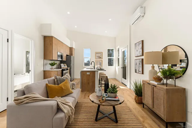 a living room with furniture a chandelier and kitchen view