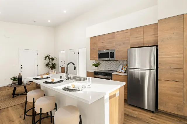 a kitchen with stainless steel appliances a table chairs and a refrigerator