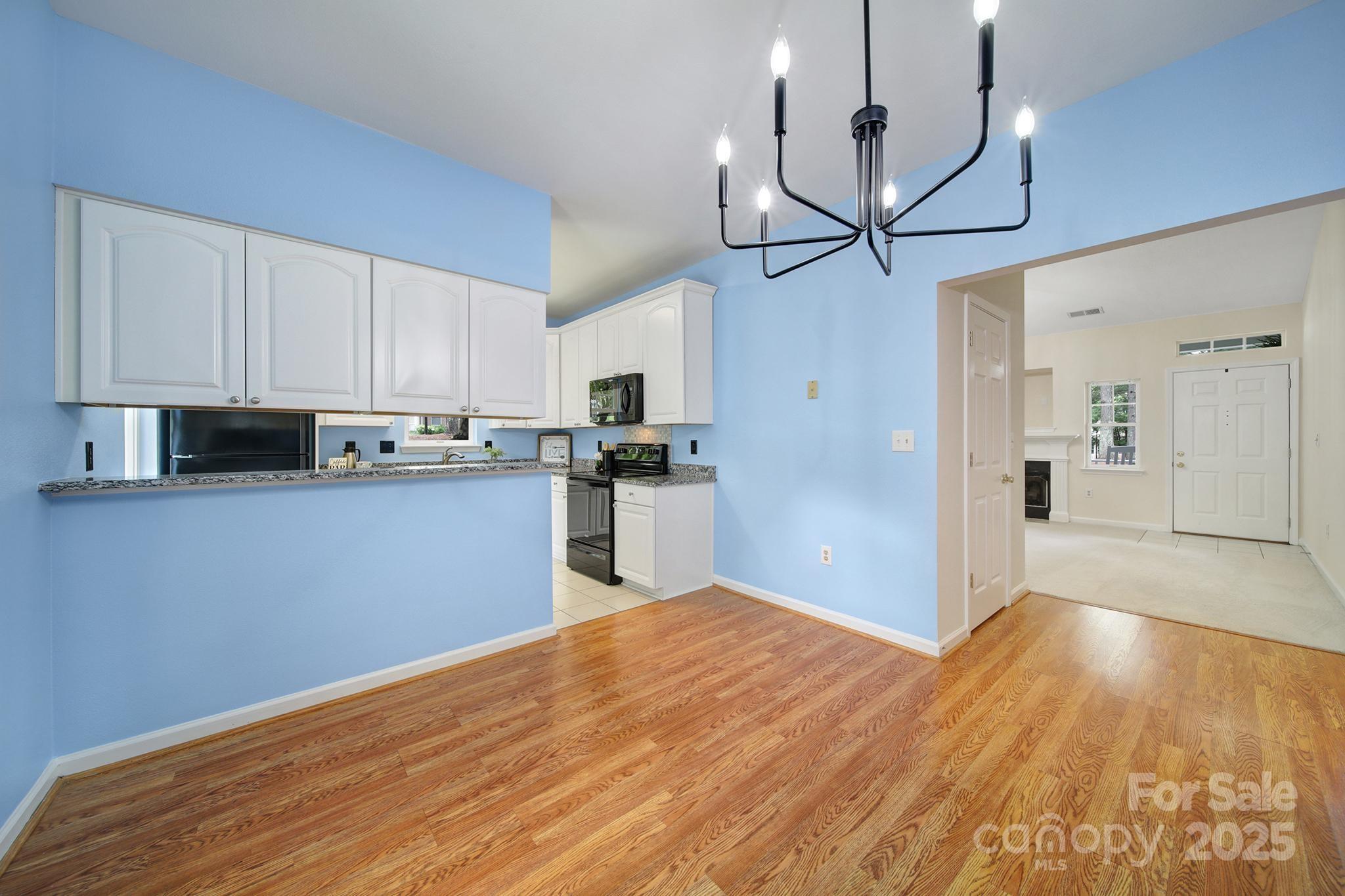 614 Stone Village Drive Fort Mill, SC 29708 - Photo 13 of 42 a kitchen with stainless steel appliances granite countertop a refrigerator a sink dishwasher a stove and white cabinets with wooden floor