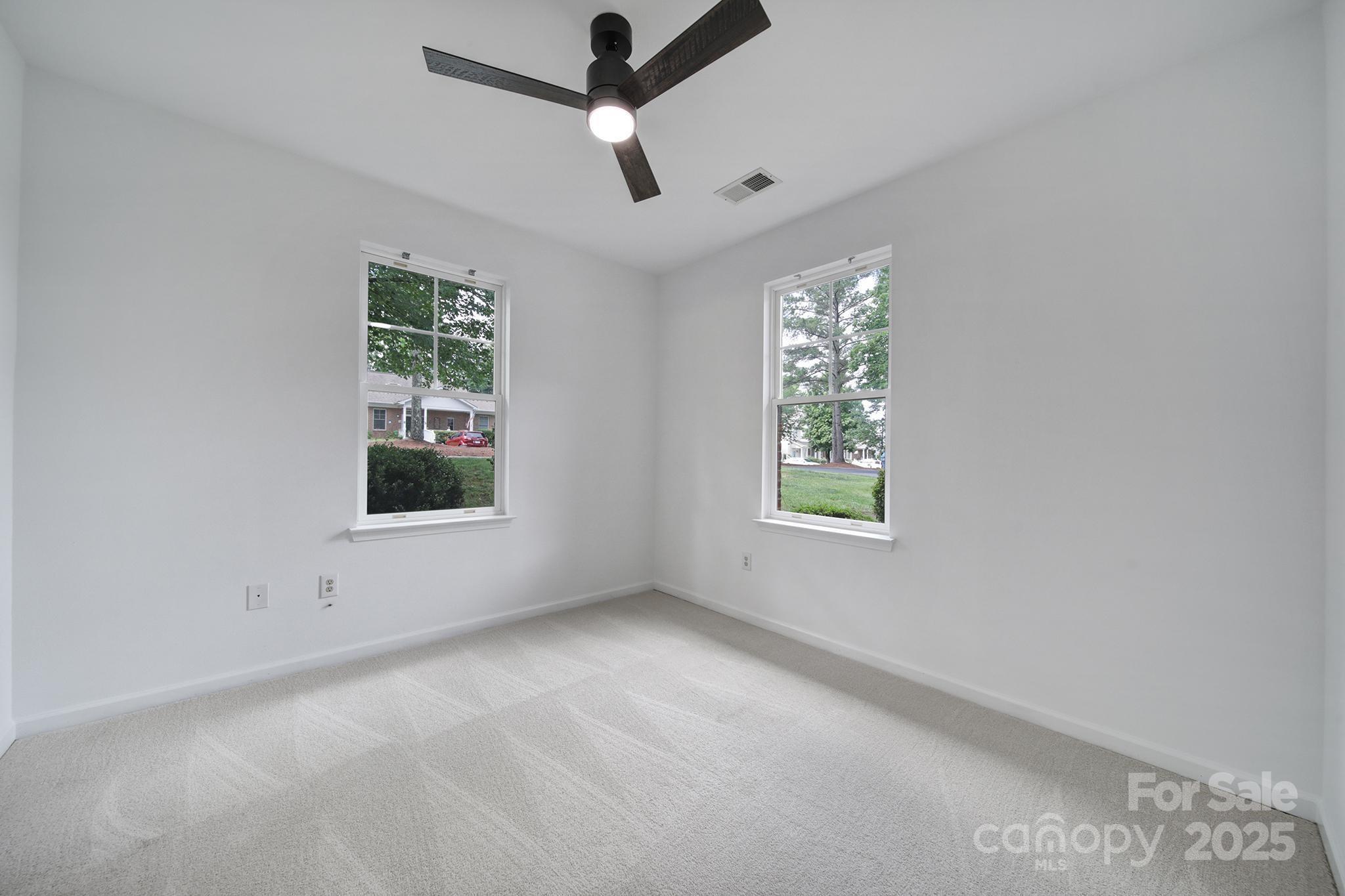 614 Stone Village Drive Fort Mill, SC 29708 - Photo 16 of 42 an empty room with windows and ceiling fan