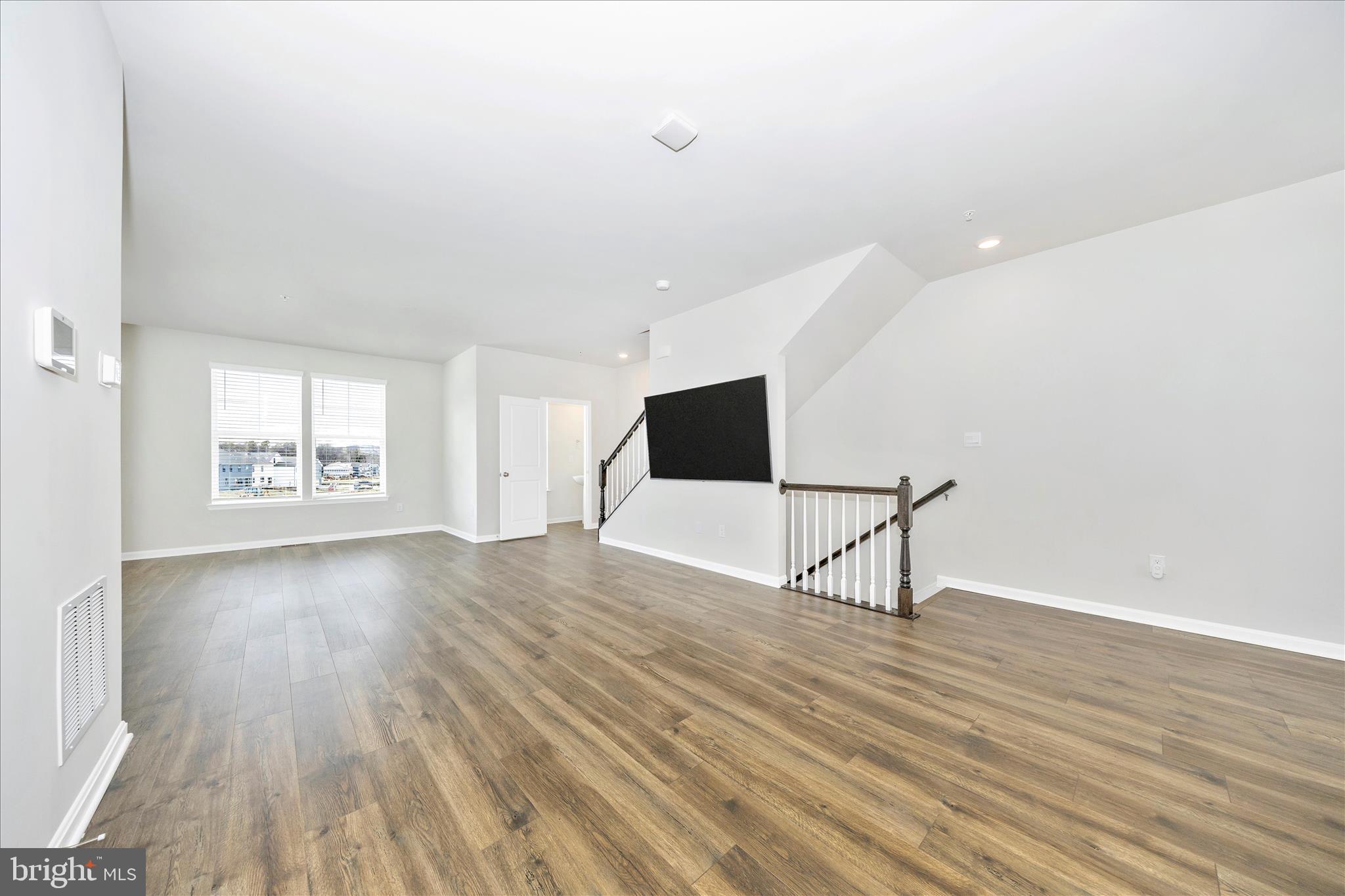 726 Compass Way Frederick, MD 21701 - Photo 24 of 55 a view of an empty room with wooden floor and a window