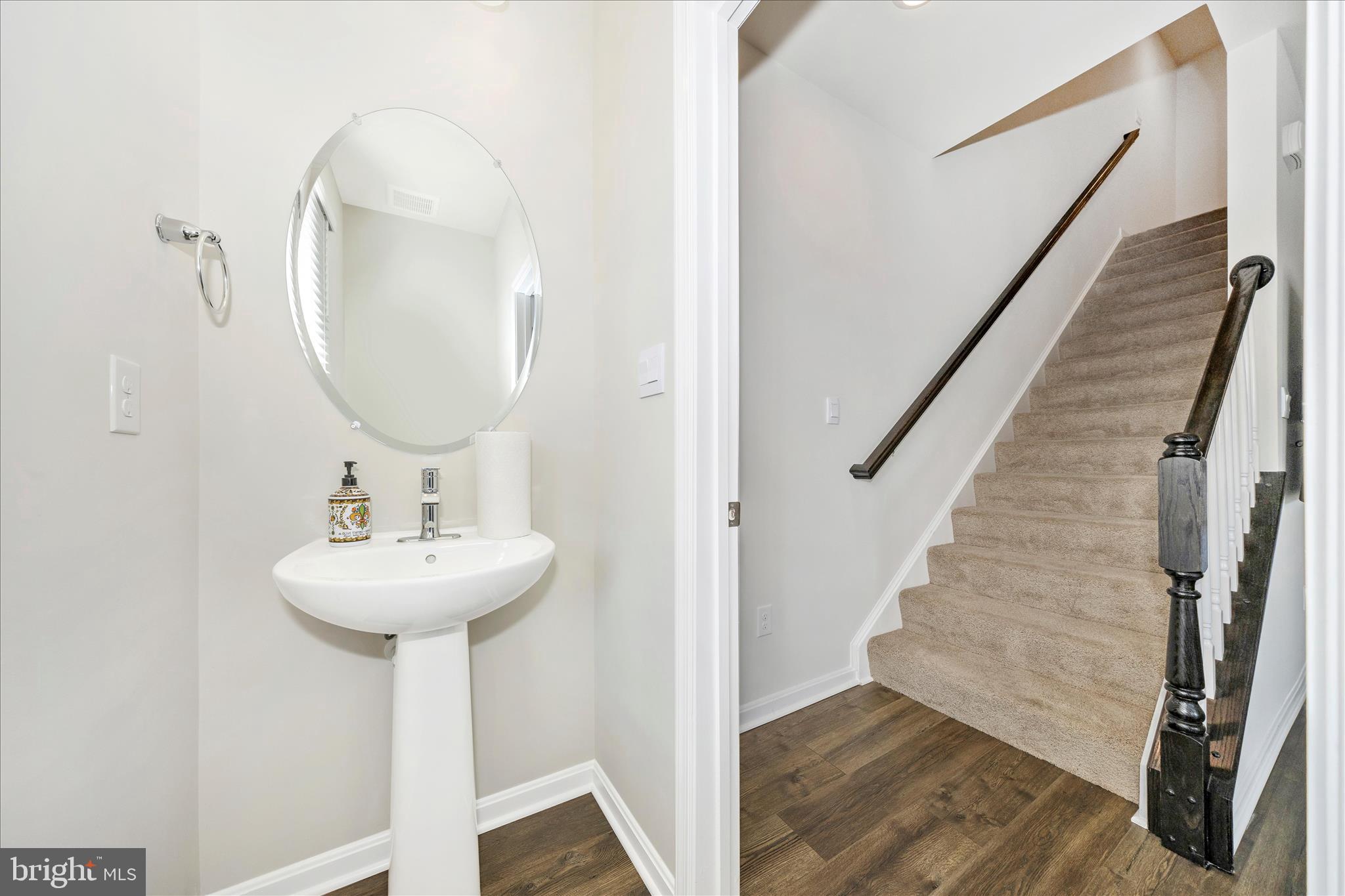 726 Compass Way Frederick, MD 21701 - Photo 28 of 55 a bathroom with a sink a mirror and wooden floor