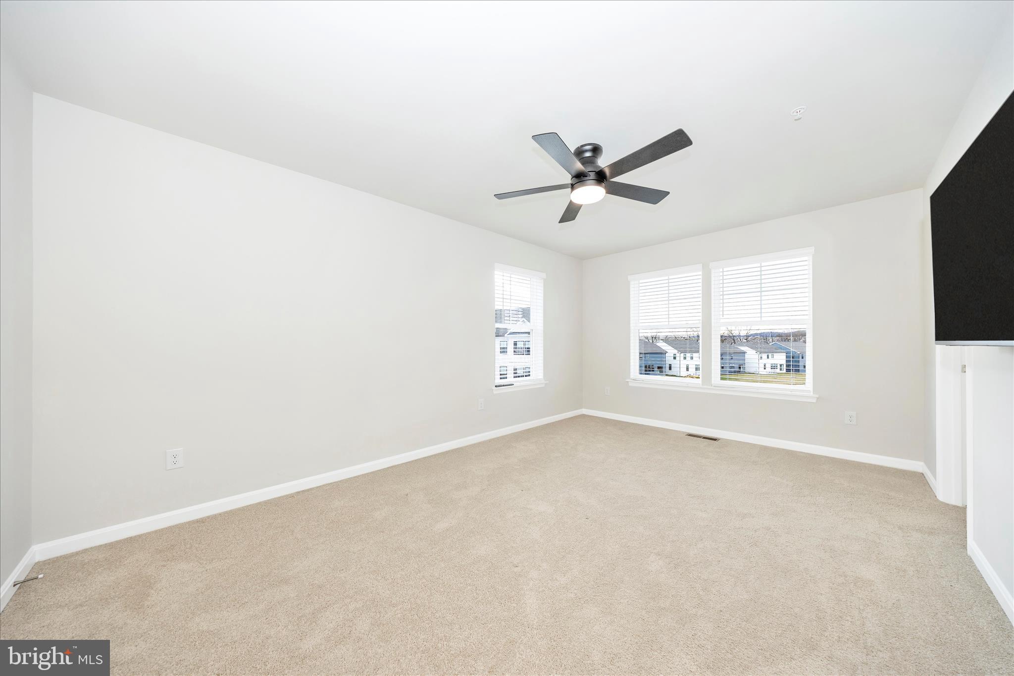 726 Compass Way Frederick, MD 21701 - Photo 34 of 55 an empty room with windows and a ceiling fan