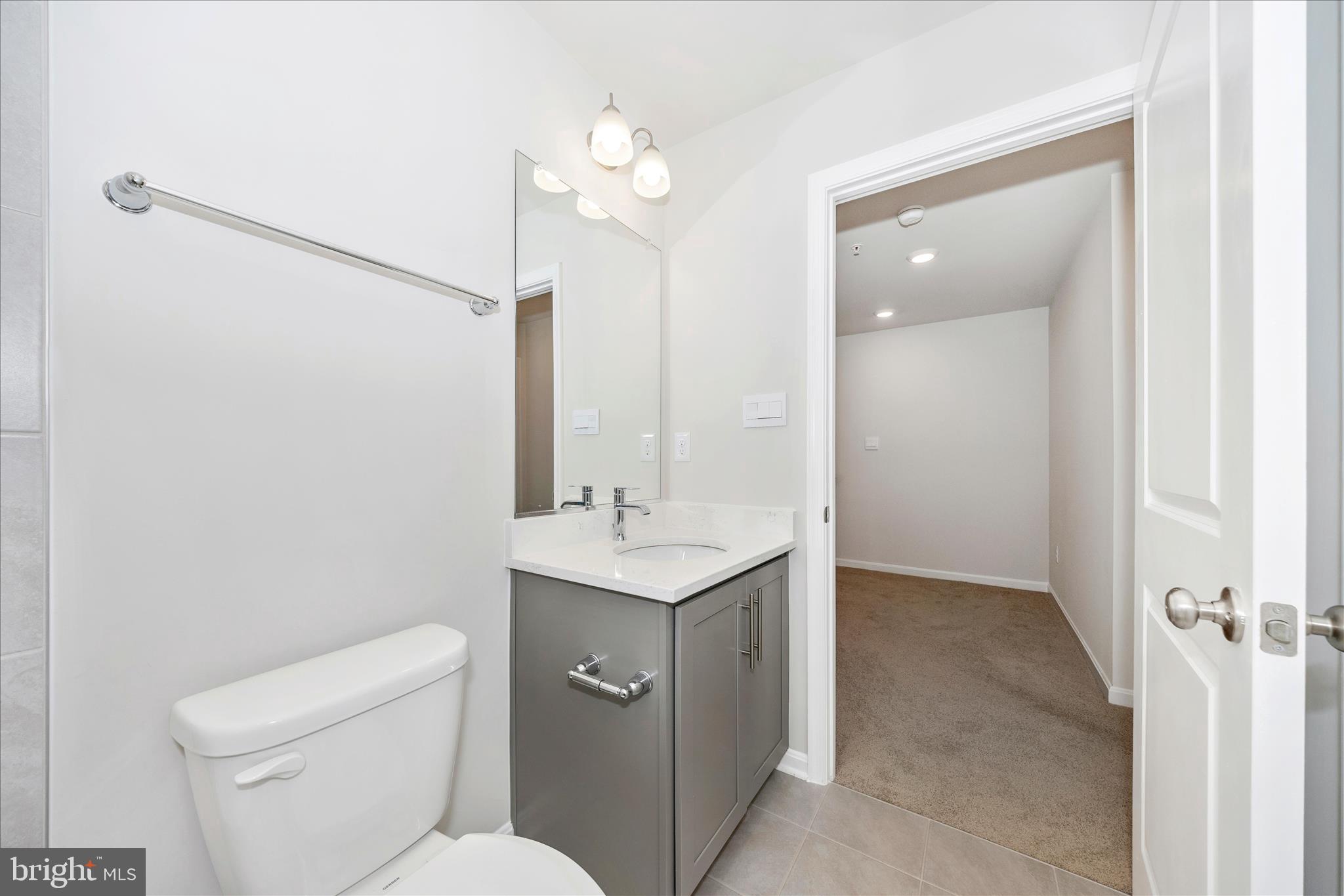 726 Compass Way Frederick, MD 21701 - Photo 47 of 55 a bathroom with a toilet a sink a mirror and vanity