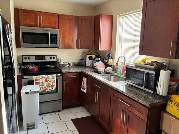 a kitchen with stainless steel appliances a stove microwave and sink