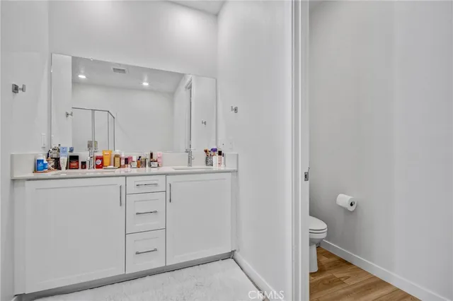 a bathroom with a sink mirror and a toilet