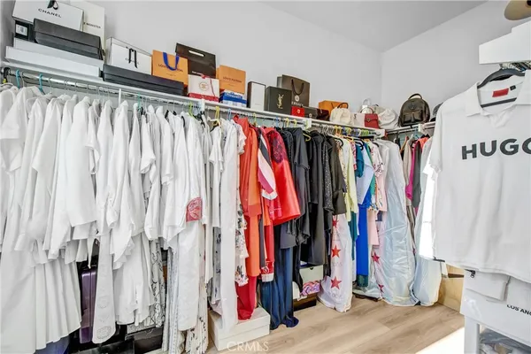 a view of walk in closet with clothes and shoes