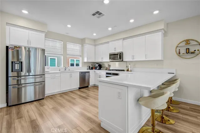a kitchen with a refrigerator a white stove top oven cabinets and a center island