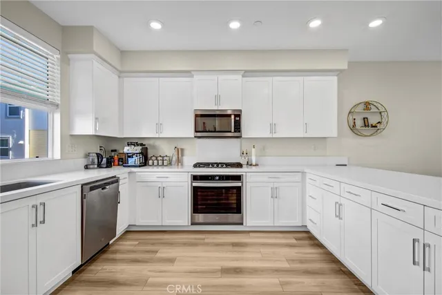a kitchen with cabinets stainless steel appliances and a counter space