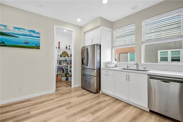a kitchen with a refrigerator cabinets and wooden floor